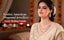 Modern Indian woman in a festive look wearing an American diamond necklace and earrings from Nuyug