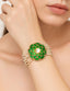 Model wearing a gold-toned multi-strand pearl bracelet featuring a green enamel circular motif with kundan accents and faceted green beads