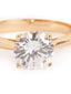 Close up shot of a gold-toned solitaire ring featuring a brilliant round-cut AAA cubic zircon stone on a sleek band
