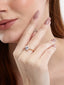 Model wearing a gold-toned solitaire ring featuring a brilliant round-cut AAA cubic zircon stone on a sleek band